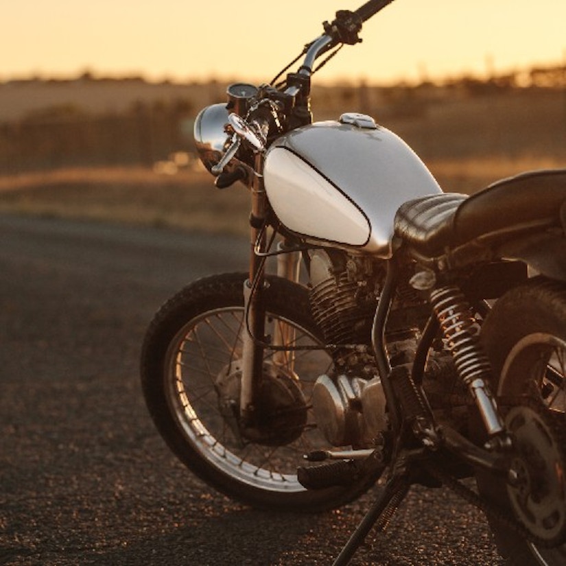Ein Motorrad, das auf einer einsamen Straße steht