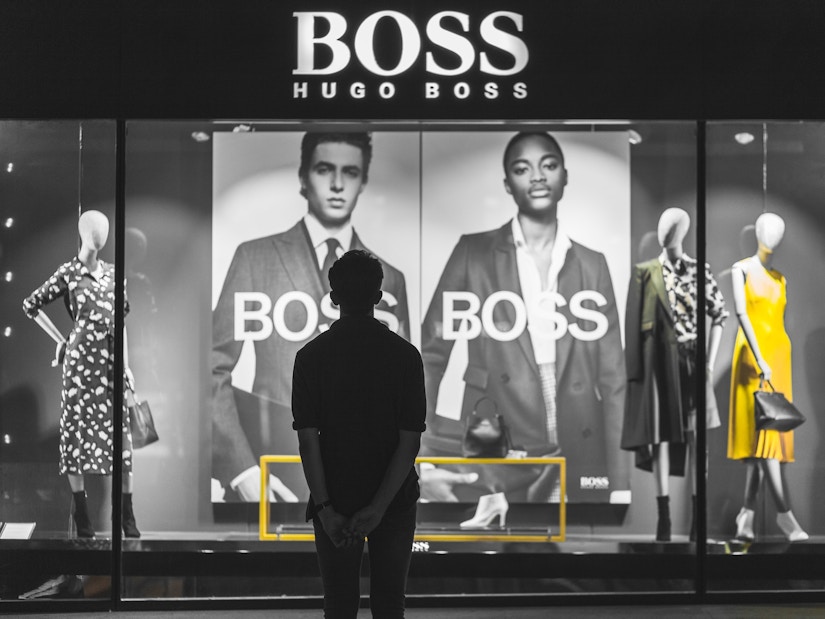 Ein Mann steht vor einem Hugo Boss Store
