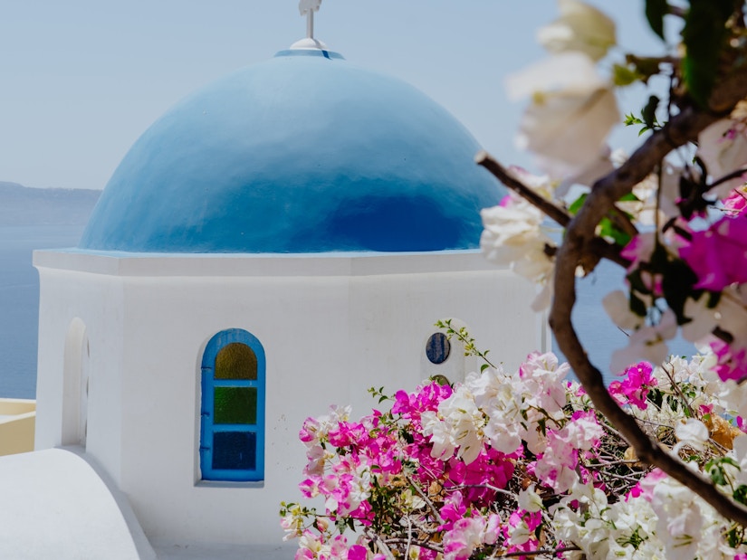 Weiß getünchtes Gebäute hinter Blumen am Mittelmeer