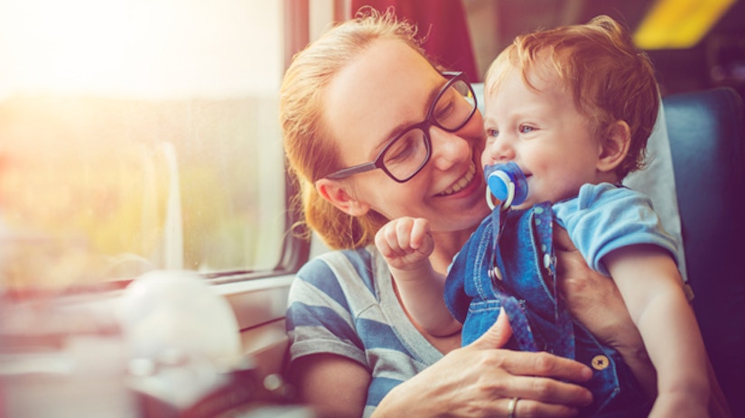 Eine Mutter und ihr Sohn sitzen in einer Bahn und gucken aus dem Fenster.