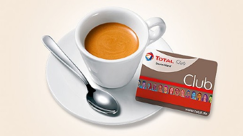 Eine Tasse Espresso, daneben liegt die Total Club Kundenkarte