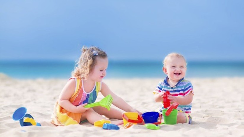 Zwei Kinder spielen am Strand.