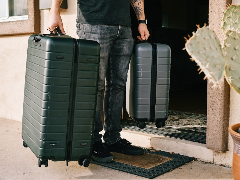 Mann trägt zwei Koffer