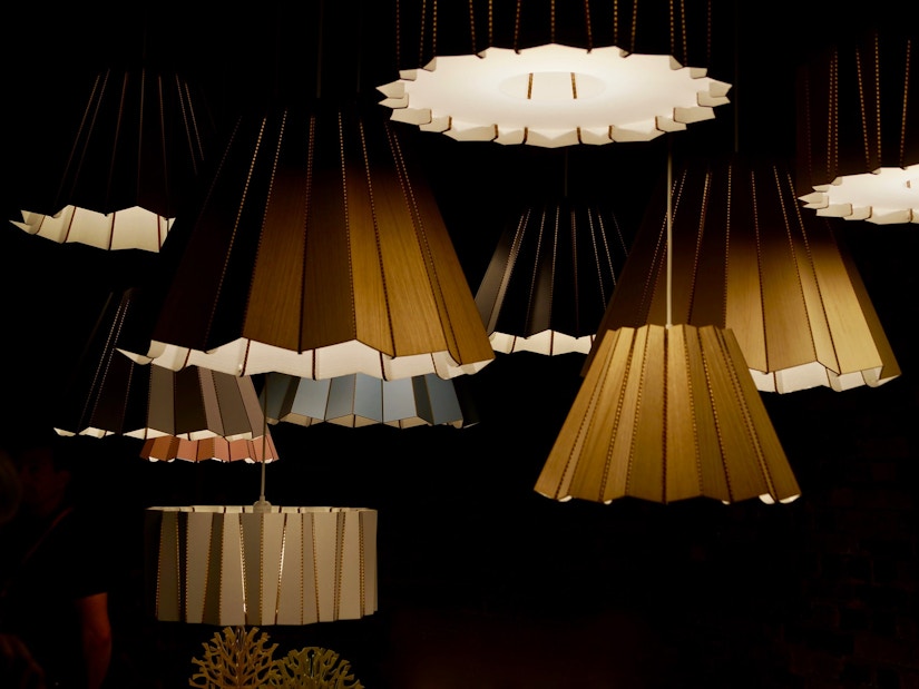 Verschiedene Lampen mit gefalteten Lampenschirmen in einem dunklen Raum