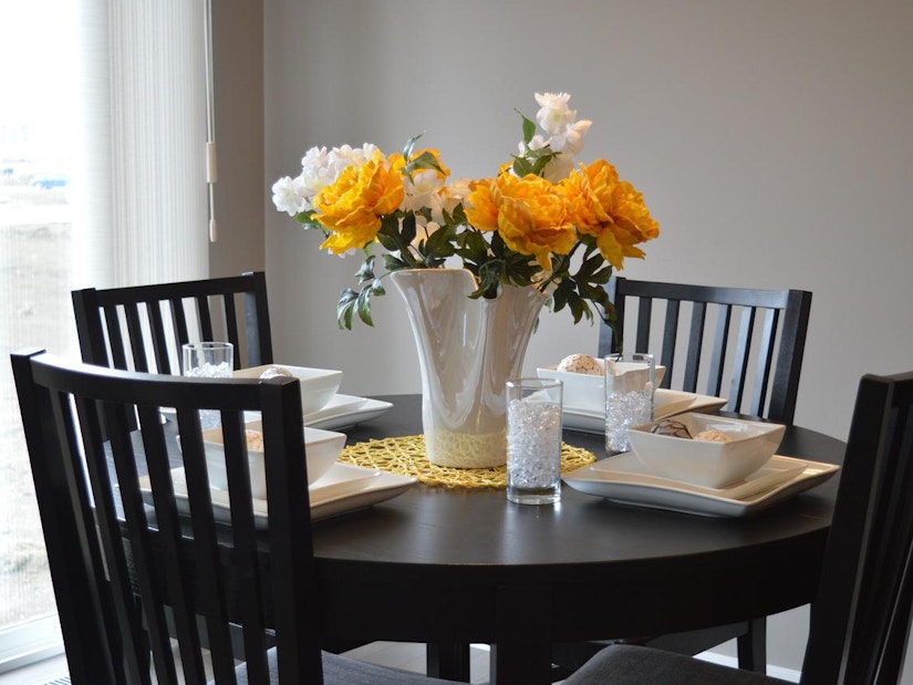 Auf dem Tisch steht eine Vase mit Blumen und Besteck