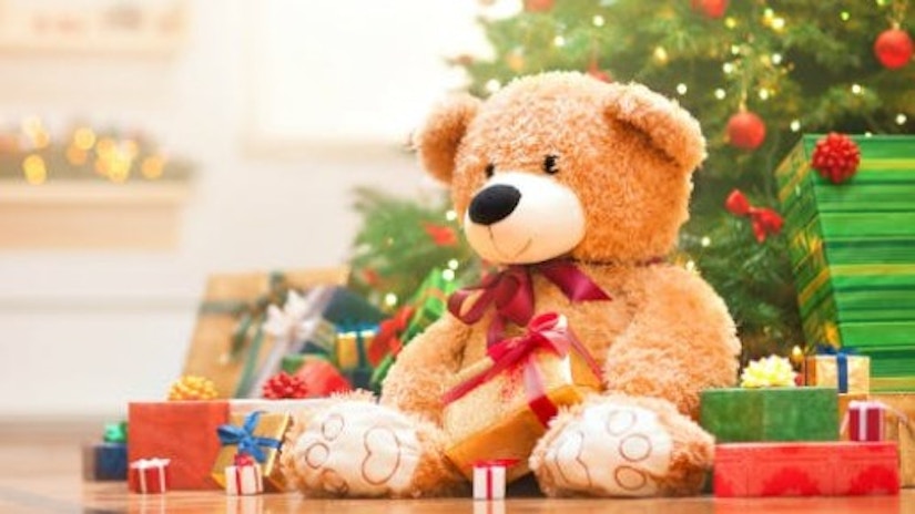 Ein Teddybär unter einem Weihnachtsbaum.