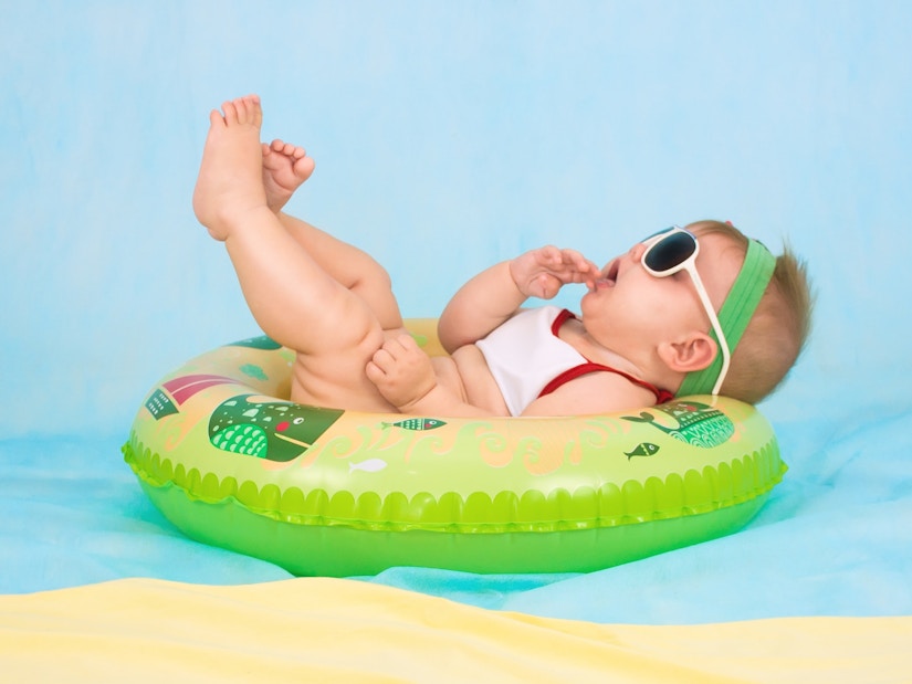 Baby mit Sonnenbrille liegt auf dem aufblasbaren Ring