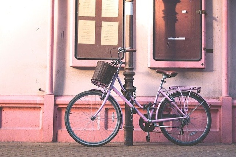 Rosa Fahrrad vor rosa Hauswand