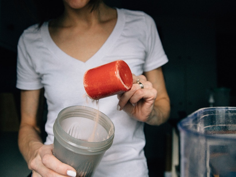 Frau bereitet einen Protein-Shake zu