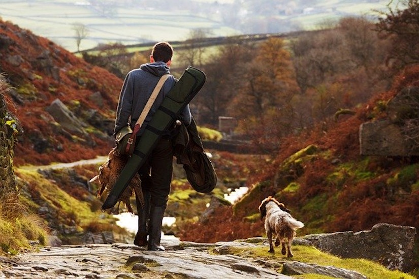 Jäger mit Hund in herbstlicher Landschaft