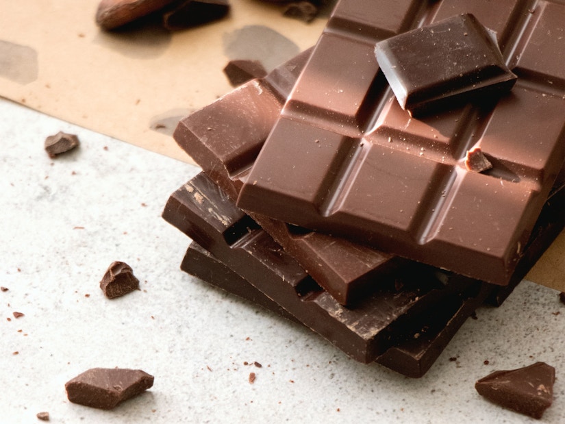 Kakaobohnen und Tafeln dunkler Schokolade liegen auf Tisch