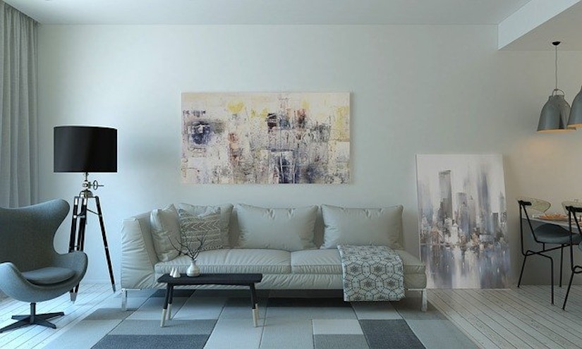 Stilvolles Wohnzimmer mit Bildern, weißem Sofa und einer eleganten Stehlampe