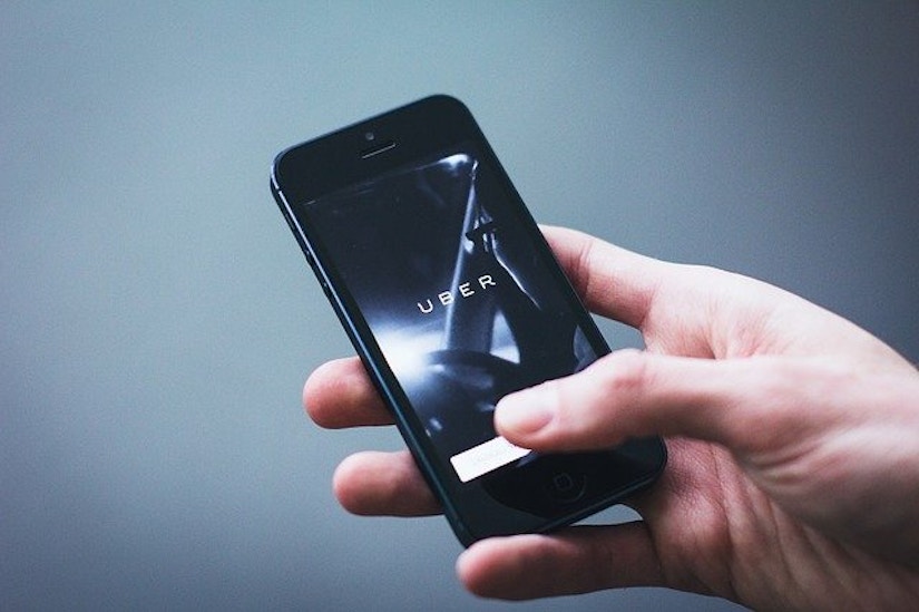 Hand hält Handy mit Uber App