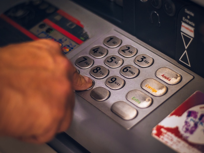 Person hebt Geld aus den Geldautomat ab
