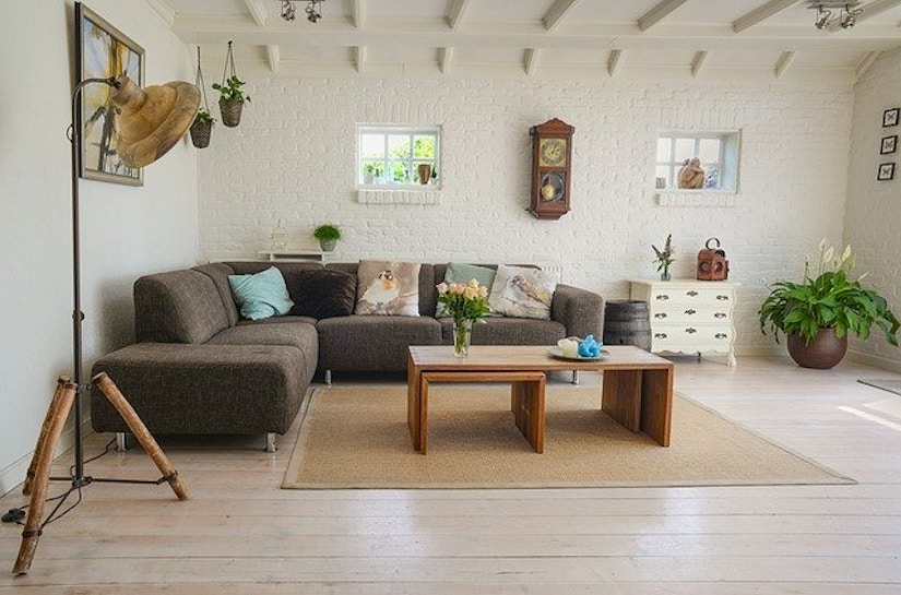 Wohnzimmer mit Sofa, Stehlampe, Couchtisch, Pflanzen