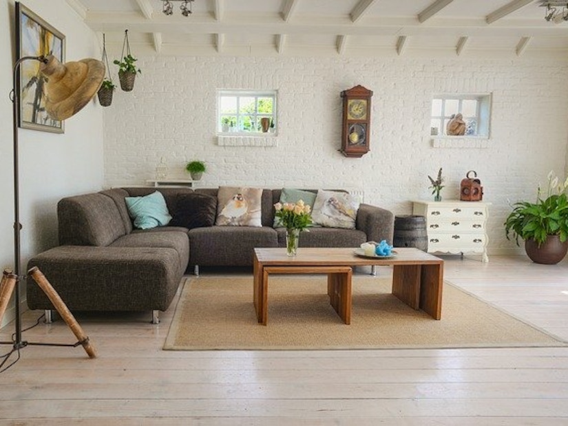 Wohnzimmer mit Sofa, Stehlampe, Couchtisch, Pflanzen