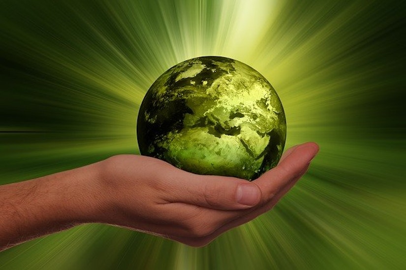 Hand hält grüne Erde