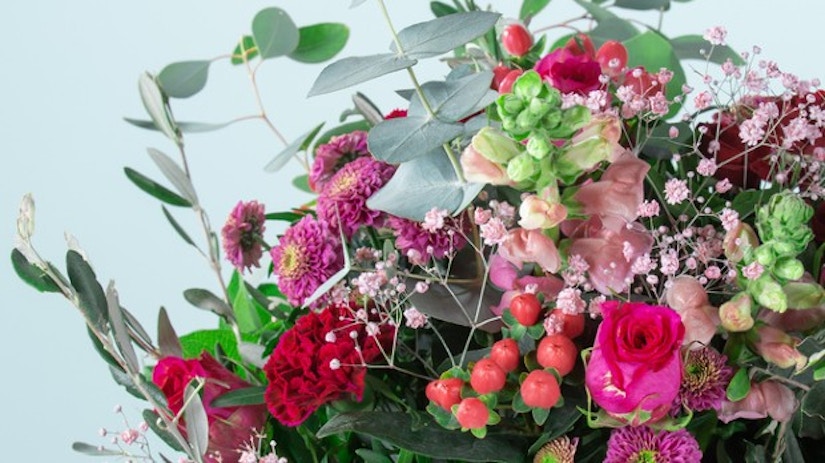 Ein Blumenstrauß aus Chrysanthemen, Johanniskraut, Nelken und Rosen.