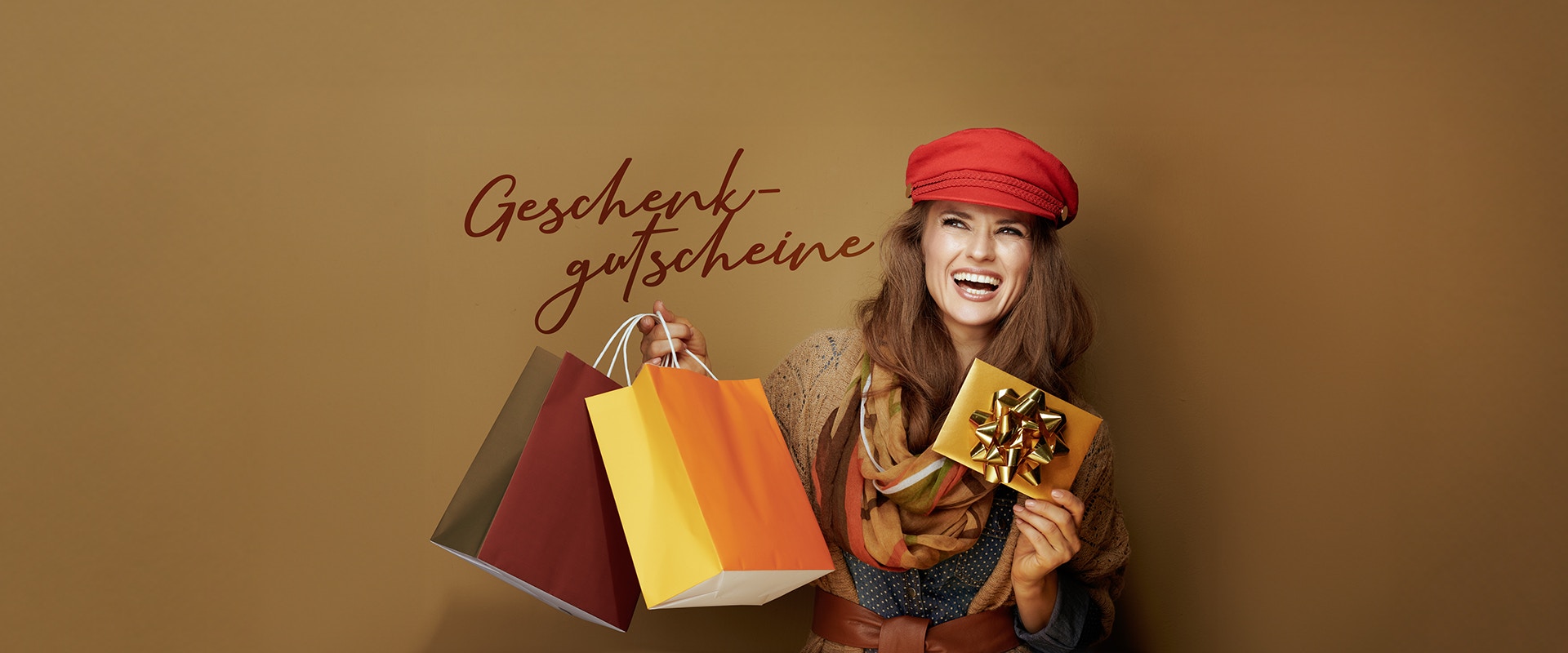 Eine lachende Frau mit Einkaufstüten und einem Briefumschlag.