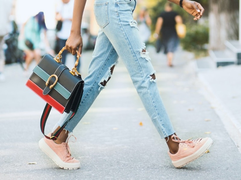 Frau mit Jeans, Sneaker und Handtasche