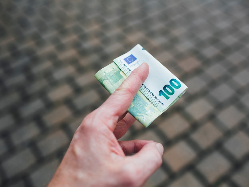 Eine Person hält einen 100-Euro-Schein in der Hand