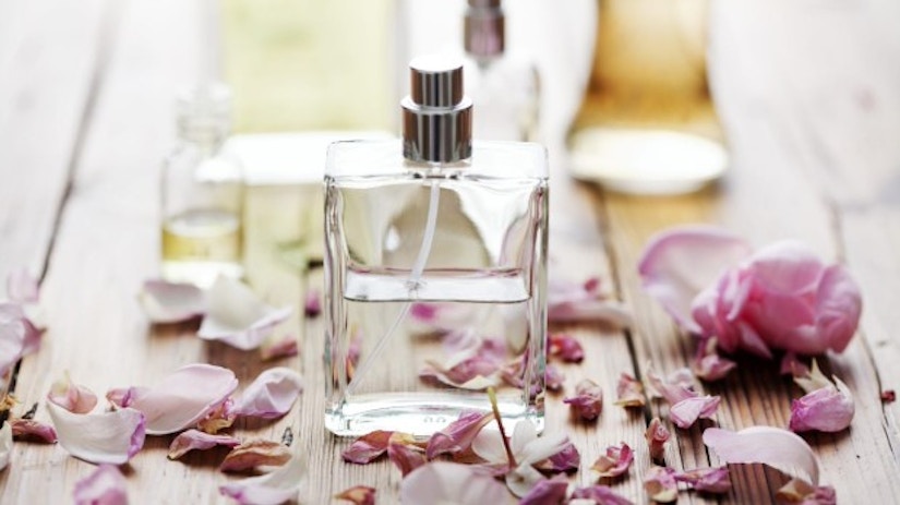Ein Parfüm-Fläschchen zwischen Rosenblättern