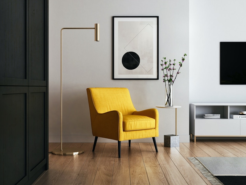 Schick eingerichteter Raum mit Parkett, Designlampe und gelbem Sessel