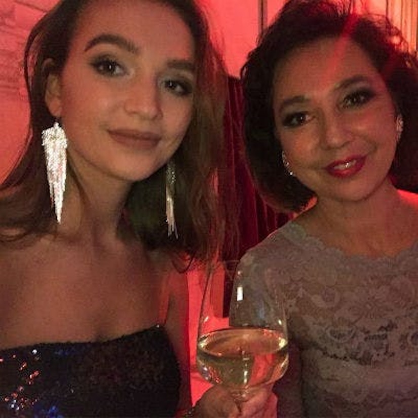 Eine junge Frau mit einem Glas Wein in der Hand und ihre Mutter.