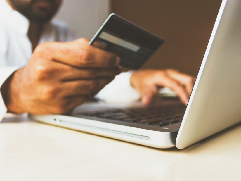 Mann shoppt online mit Kreditkarte
