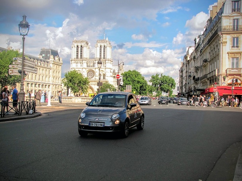 Fiat auf pariser Straße. Im Hintergrund die Kathedrale Notre Dame.