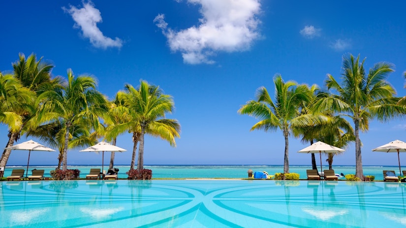 Ein Hotelpool, Palmen, Meer