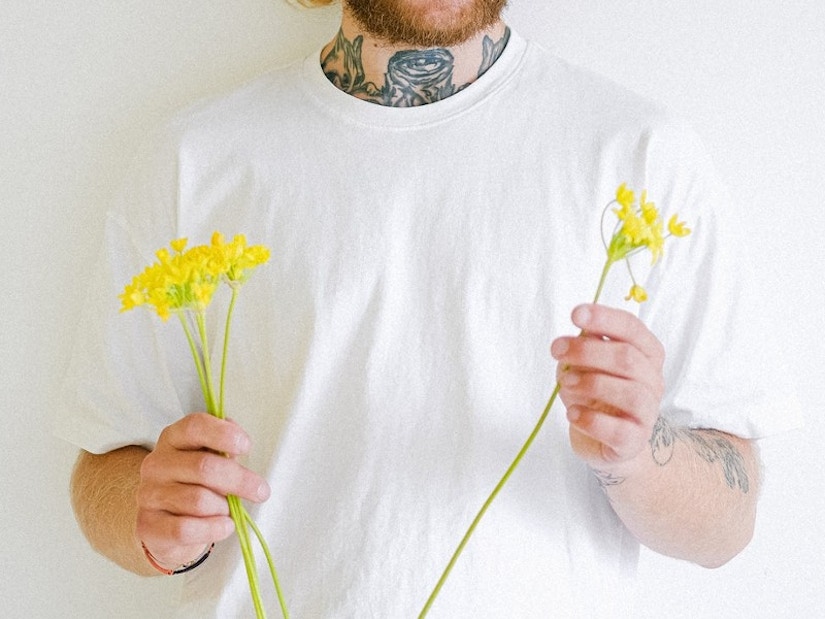 Mann mit weißem T-Shirt und Blumen